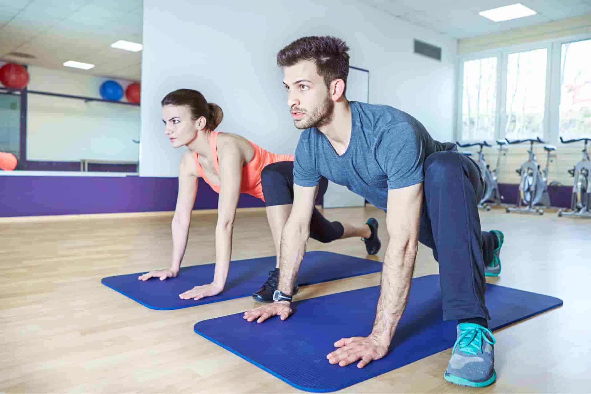 Pareja entrenando con entrenador personal en sala privada del estudio Healthy Fitness Madrid junto al Retiro